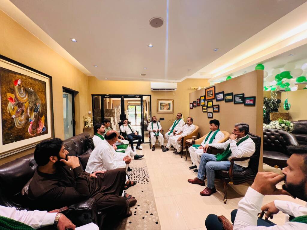 HAAF Group team gathered around a green and white Independence Day cake during the 14th August celebration