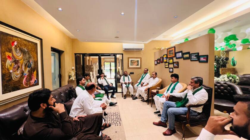 HAAF Group team gathered around a green and white Independence Day cake during the 14th August celebration