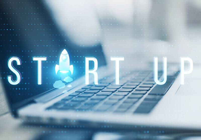 Close up of laptop with creative text and spaceship replacing letter on blurry background with bokeh circles. Think, idea, start up, creative and inspire concept. Toned image